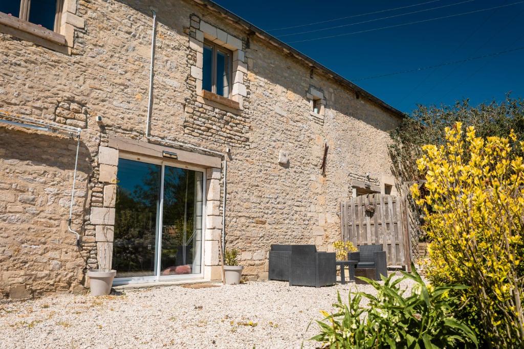 a brick building with a window and a wooden bench at Le chant des oiseaux in Ryes