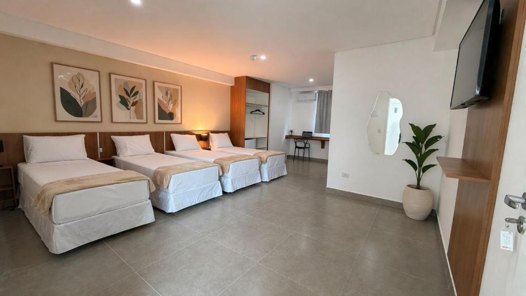 a hotel room with two beds and a flat screen tv at Smart Hotel GRU in Guarulhos