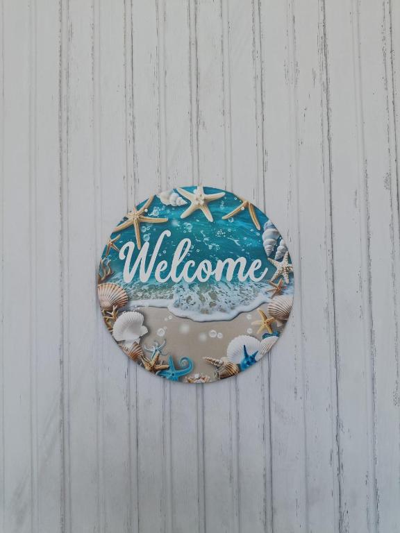 a sign that says welcome hanging on a wall at Casa Tamerici in Marcelli