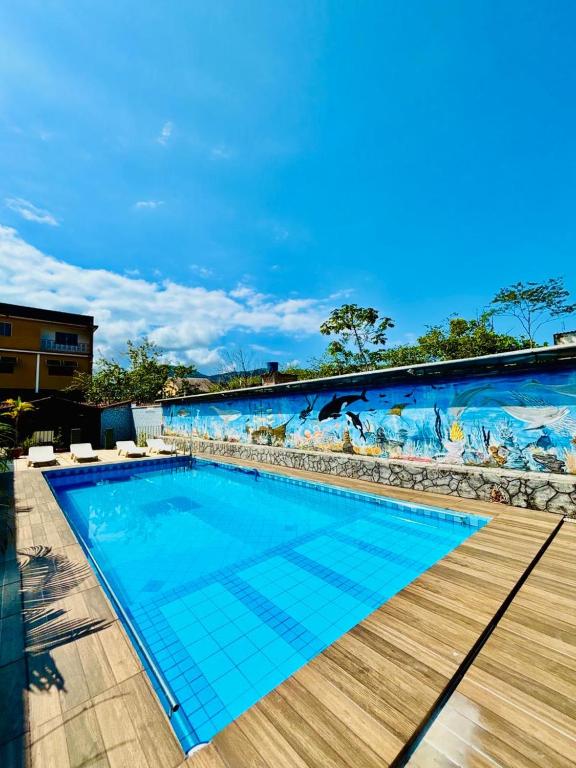 a swimming pool with a mural on the side of a building at Pousada H&D in Angra dos Reis