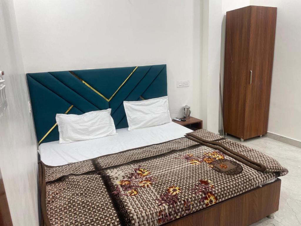a bedroom with a bed with a blue headboard at Hotel 48 in Amritsar