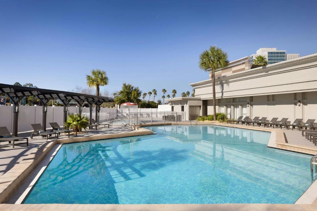 a large swimming pool with chairs and a building at Courtyard by Marriott across Universal Orlando in Orlando