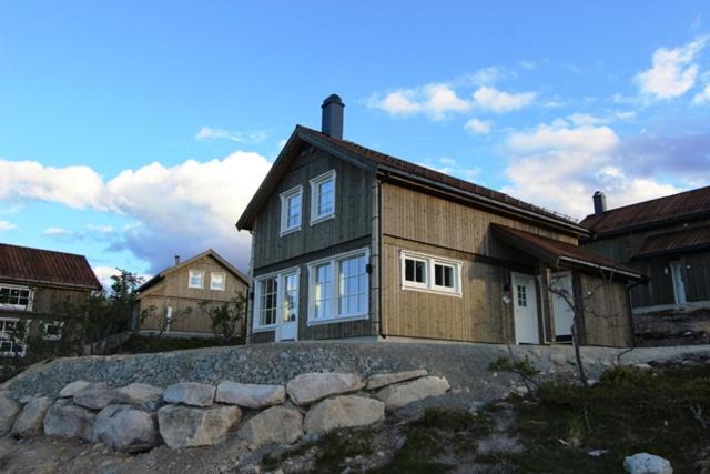 a house with a stone wall in front of it at Trysilbua 1173 in Trysil