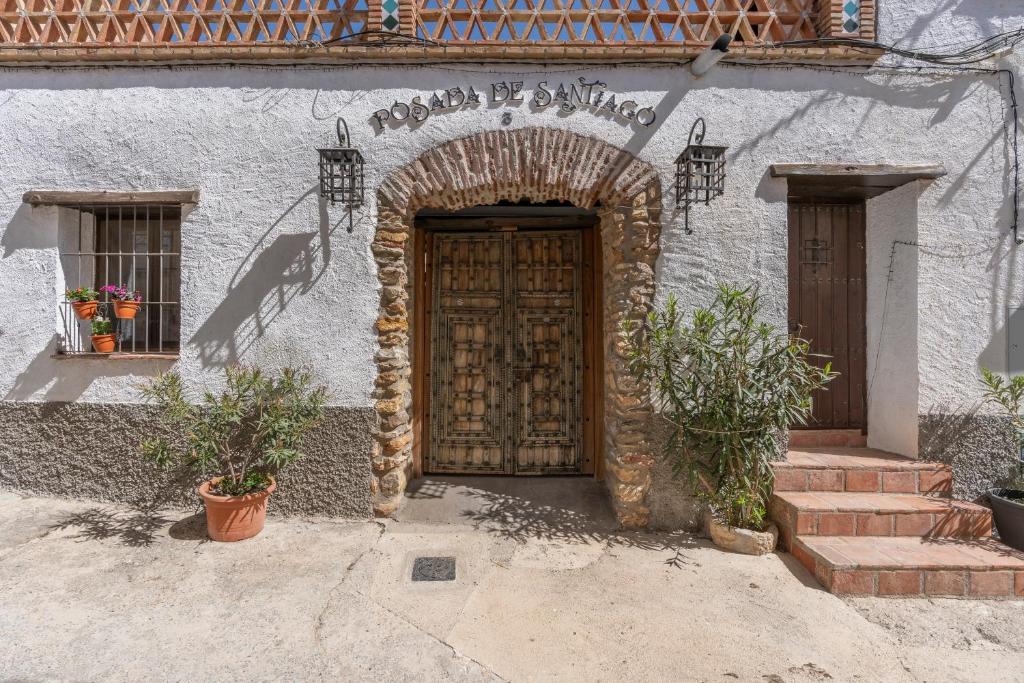 an entrance to a building with a wooden door at Posada De Santiago in Rubite