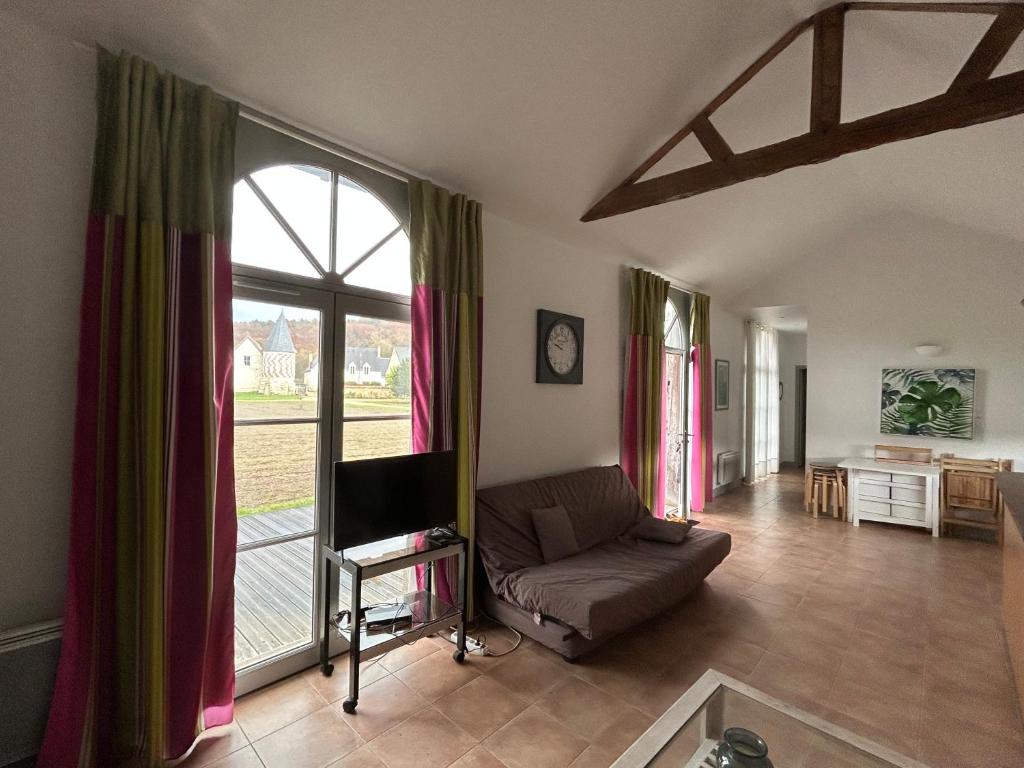a living room with a couch and a large window at Orangerie in Benais