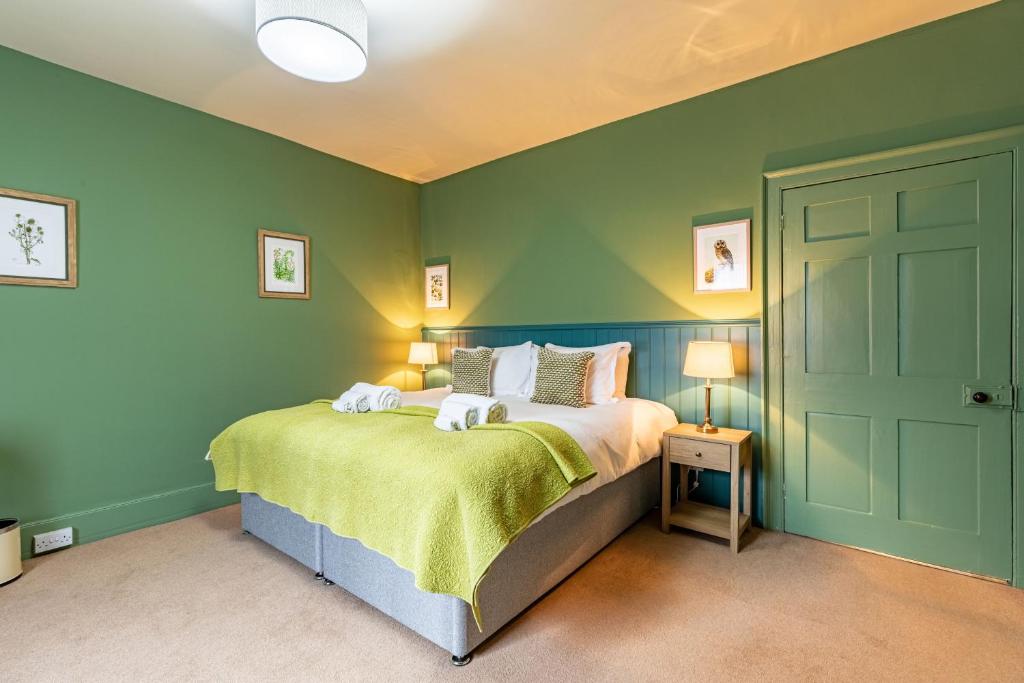 a bedroom with a bed with green walls at Dairy Green Flat in Shifnal