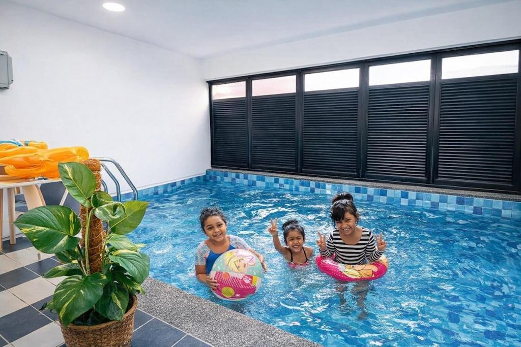 three girls are playing in a swimming pool at Walnut Grove Premium Pool Villa in Batu Caves