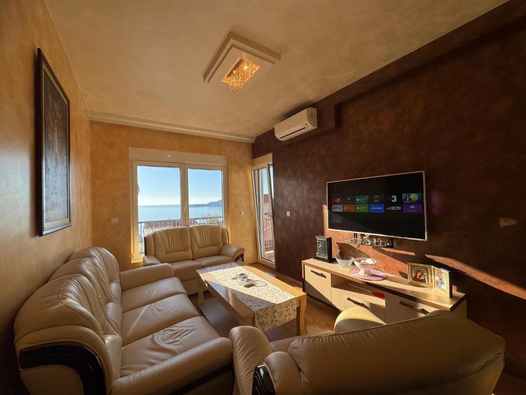 a living room with a couch and a tv at Przno Sea Pearl - Seaview Holiday apartment in Pržno