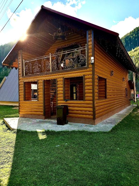 a log cabin with a balcony on top of it at Rusnak Family in Synevyrsʼka Polyana