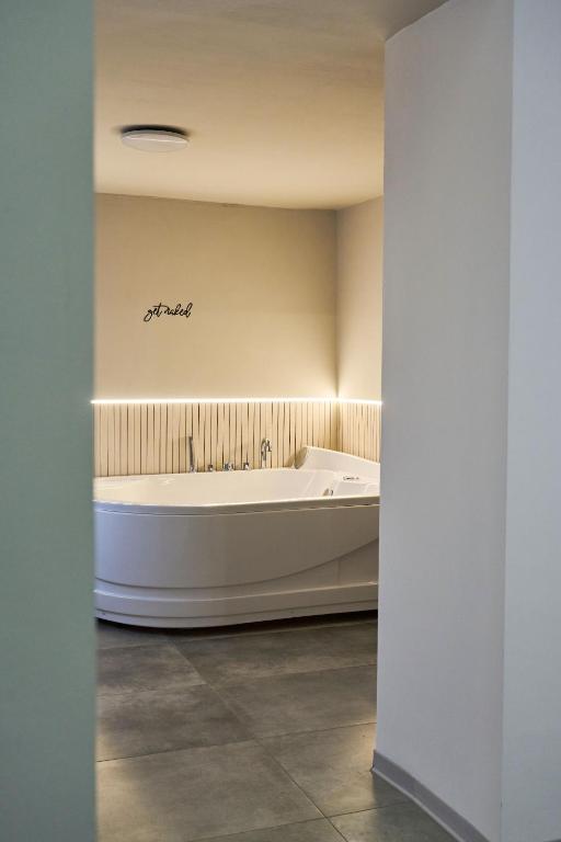 a white bath tub in a room with a ceiling at Bellosguardo Suites in San Paolo Bel Sito