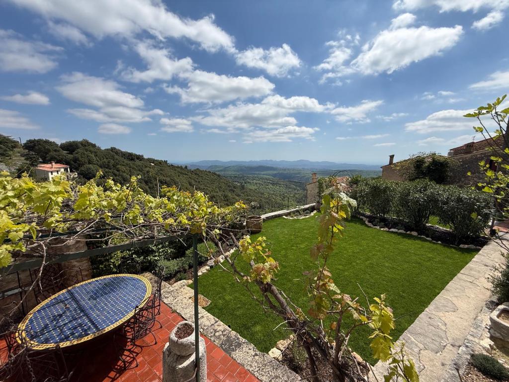 a patio with a table and a view of a garden at Le Logis - Maison authentique avec jardin et vue panoramique in Mons