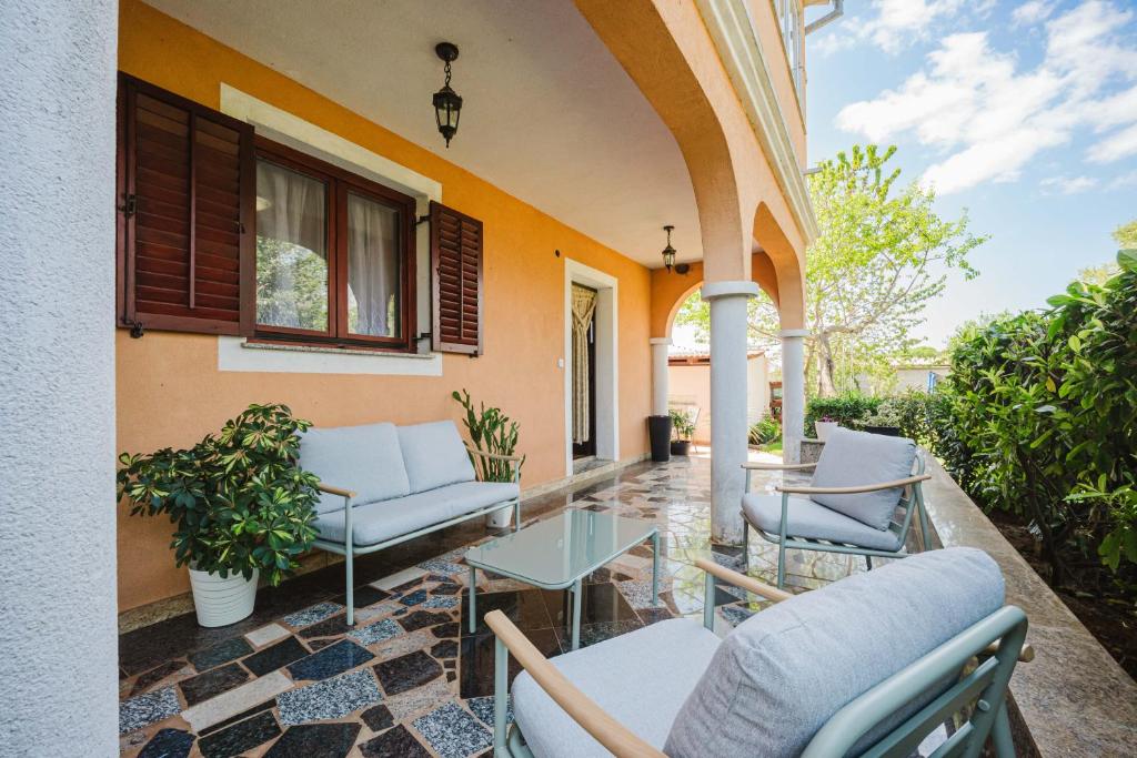 a patio with chairs and a table on a building at Apartman Mimi - Pula airport in Pula