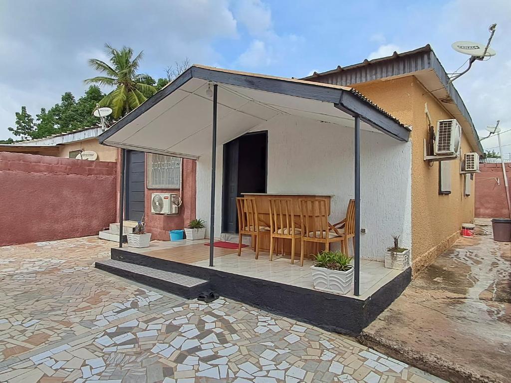 a house with a gazebo with chairs in it at 2 CHAMBRES SALON MEUBLé in Yamoussoukro