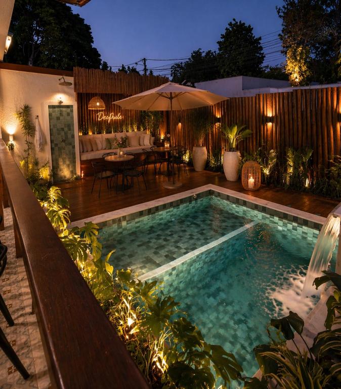 a swimming pool in a backyard at night at Desfrute Pousada e Experiencia in Arraial d'Ajuda