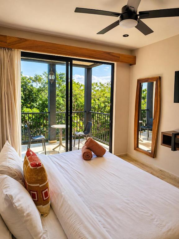 a bedroom with a large white bed and a balcony at Tuk Hacienda Studio Rooftop Pool Padel TUK in Tulum