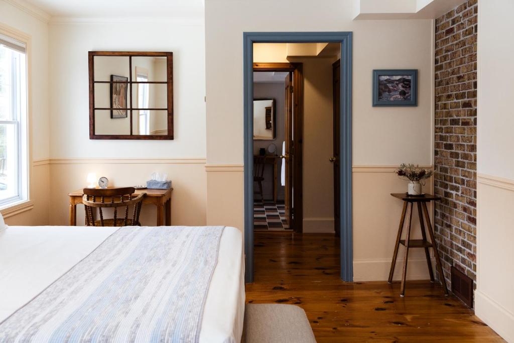 a bedroom with a bed and a brick wall at Maison Hôte in Magog-Orford