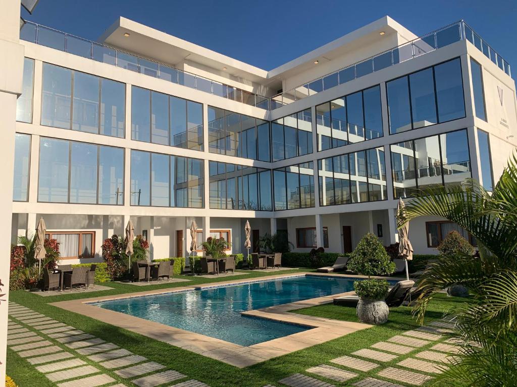 a large building with a swimming pool in front of it at Hotel Viajante in Landusane