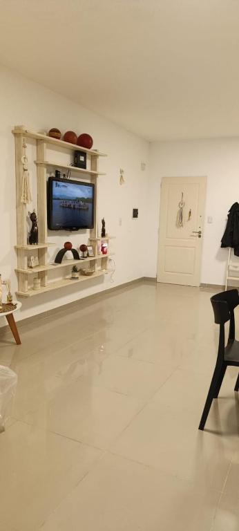 a living room with a television and a white floor at Oasis Urbano Departamento Temporal in Santiago del Estero