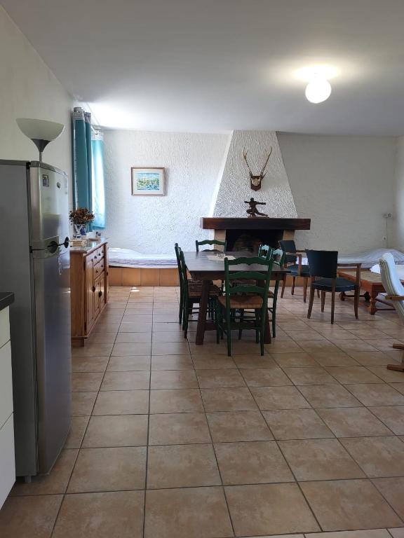 a kitchen and dining room with a table and chairs at La Ginelle - Appartement Bocage in Airoux