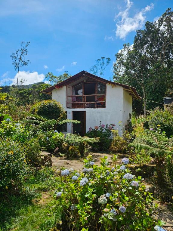 a small house in the middle of a garden at Aguadulce Climbing House in Choachí