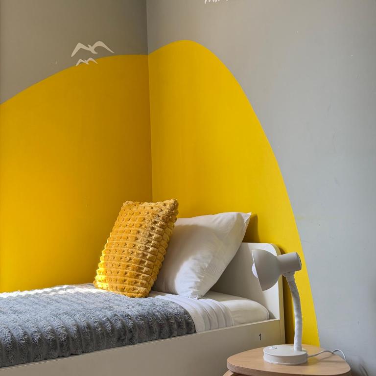 a childs room with a yellow and white wall at A Beira Hostel in Aveiro