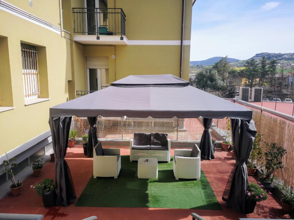 a gazebo with a couch and chairs on a balcony at ElyCry B&b in Camerano