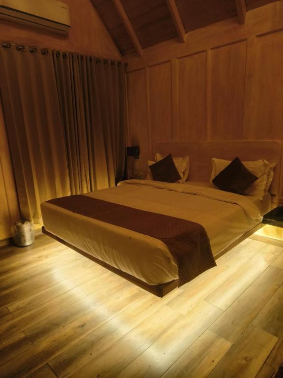 a large bed in a bedroom with a wooden floor at The Corbett Lads in Tota Ām