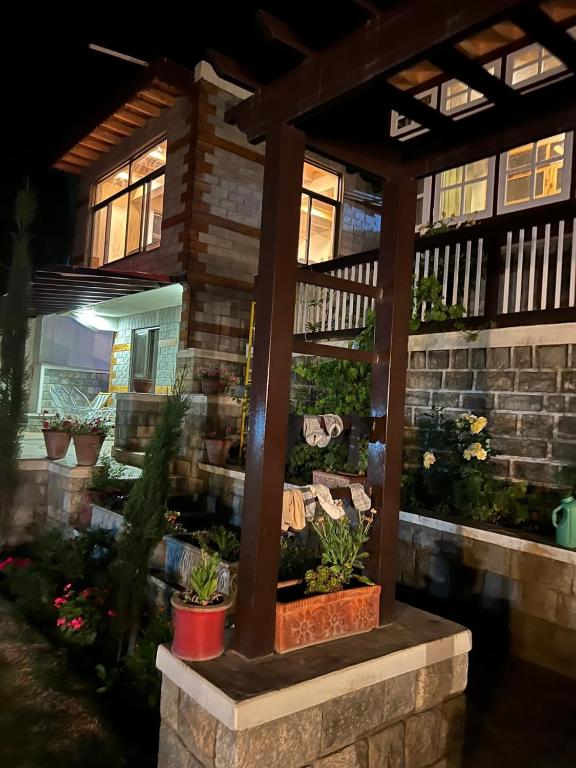 a pergola with potted plants in front of a house at Haven & Hearth in Hunza Valley