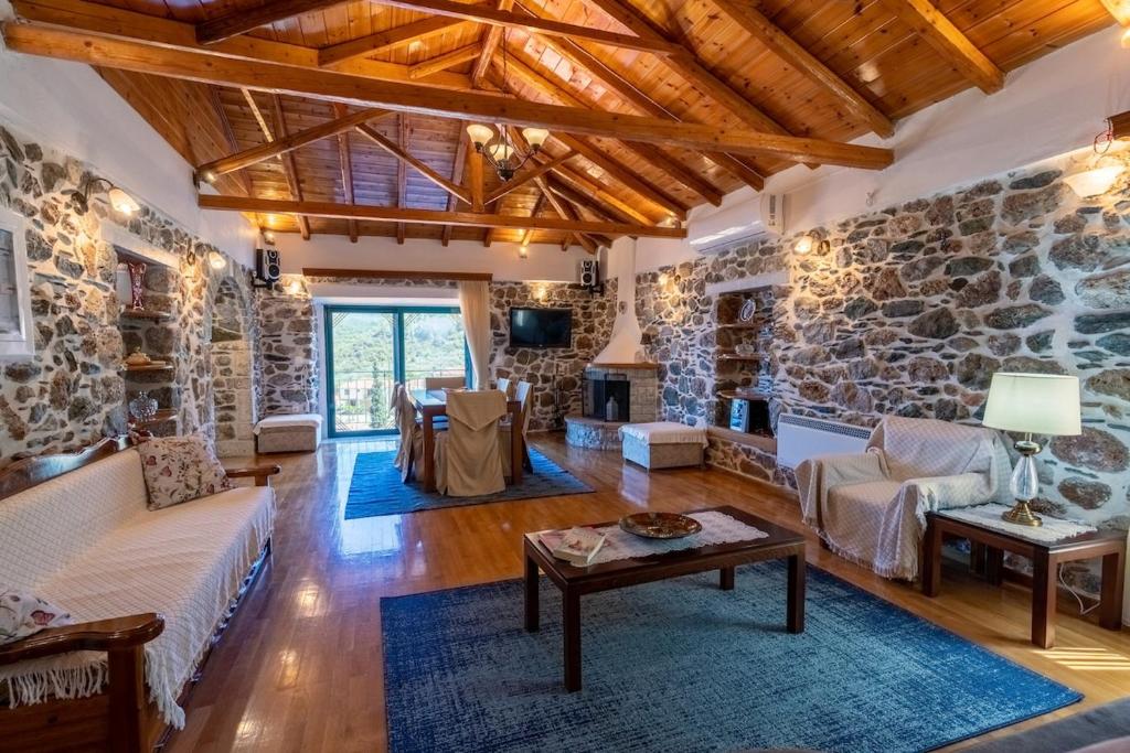 a living room with a stone wall at Kamara House in Tyros