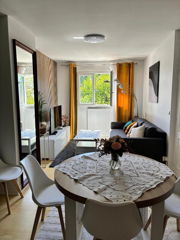 a living room with a table and a couch at LA Petite ferme 1 in Saint-Maur-des-Fossés