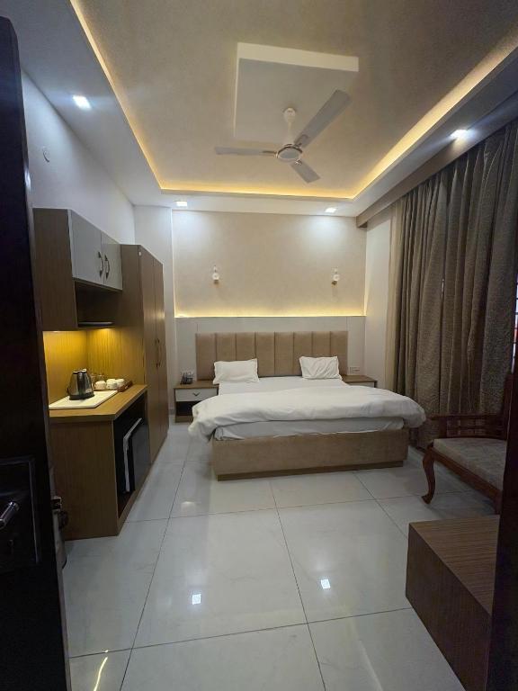 a hotel room with a bed and a desk at Hotel Nirmal Bhawan Haridwar in Haridwār