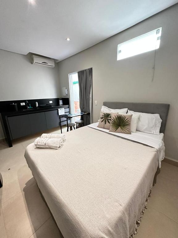 a large white bed in a room with a piano at Studio Matriz 1 e 2 in São Sebastião