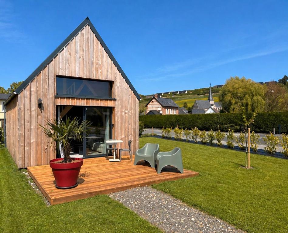 a wooden deck with two chairs and a table at Tiny Chalet in Paluel