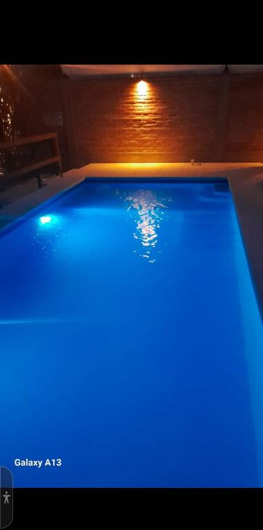 a swimming pool with blue lighting in a house at Departamentos Algarrobo in Arroyo de Los Patos