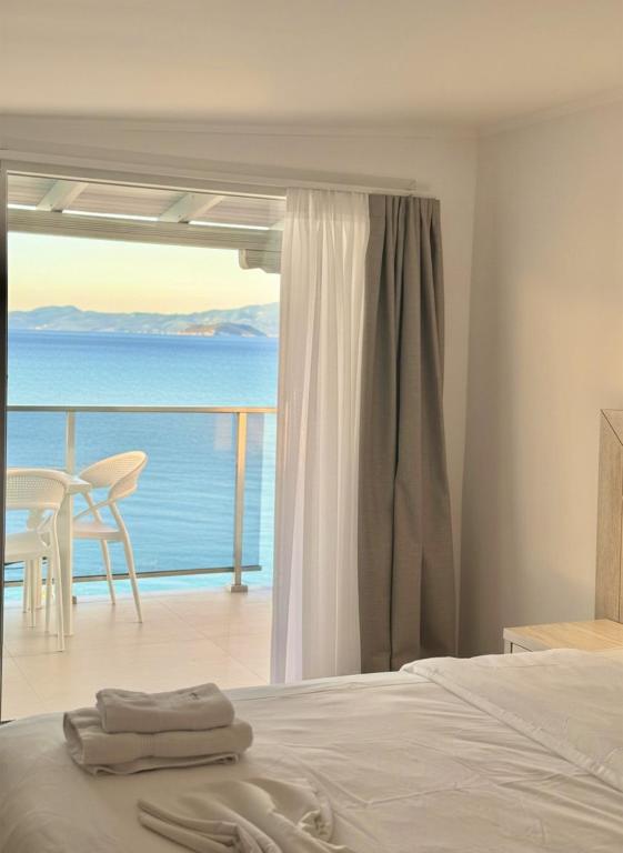 a bedroom with a bed and a view of the ocean at Myrto Rooms in Pefkochori