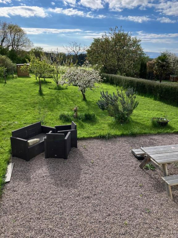 a garden with a couch and a picnic table at Ma maison in Créhen