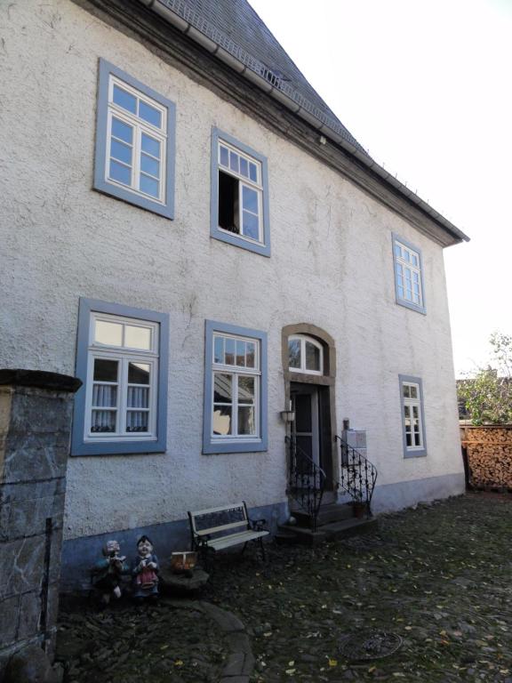 a white building with blue windows and a bench at Altstadthaus in Arnsberg