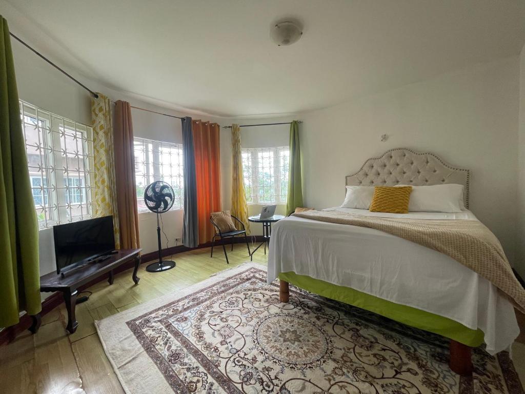 a bedroom with a bed and a flat screen tv at Bright Bay Garden Suite in Montego Bay