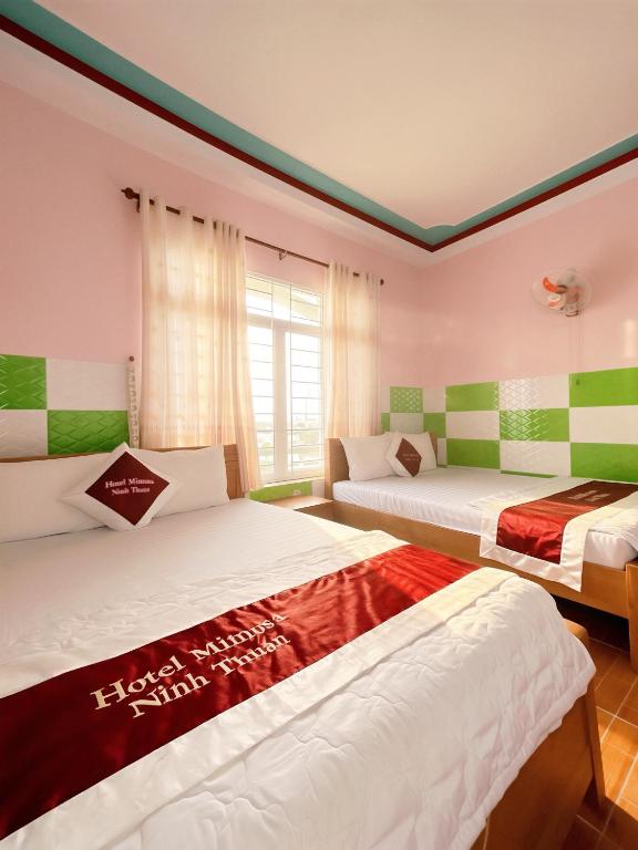 a bedroom with two beds and a window at Mimosa 5 Hotel - Phan Rang in Bắc Sớn