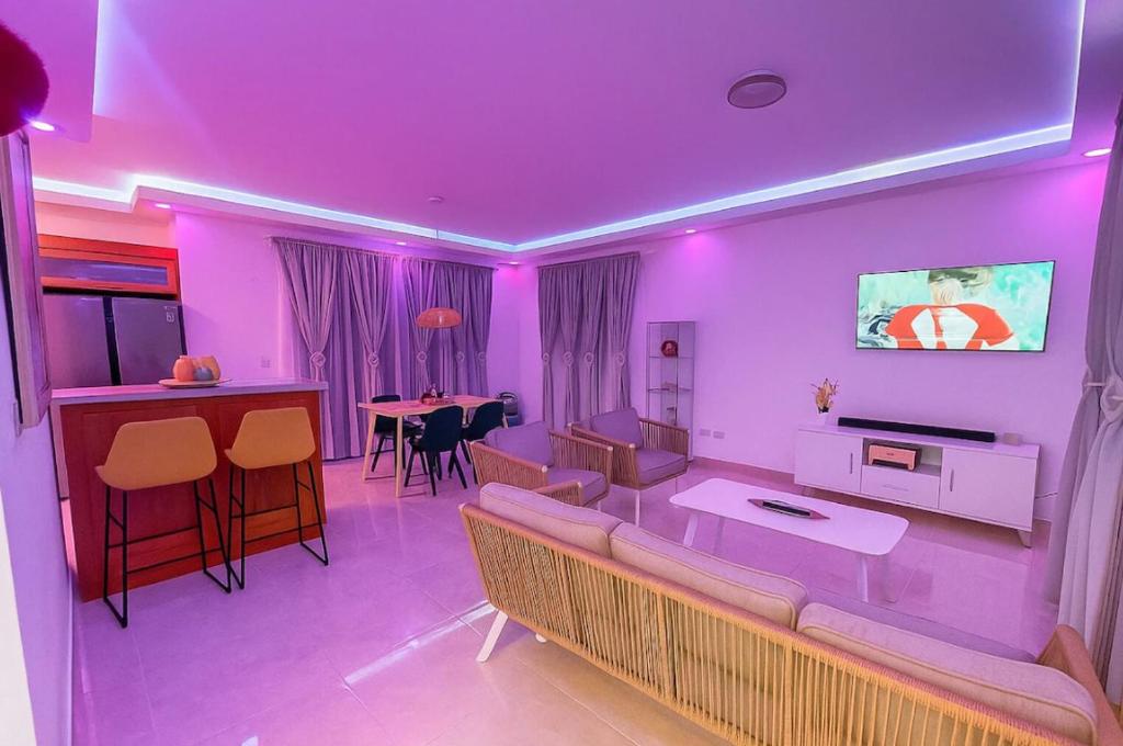 a living room with purple lighting and a couch and a table at Luxury Comfort Villa in Punta Cana