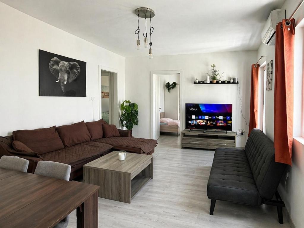 a living room with a couch and a tv at Calypso 3 Large Stylish Apartment in Paceville with Mercury Tower View Ideal for Groups in St. Julianʼs