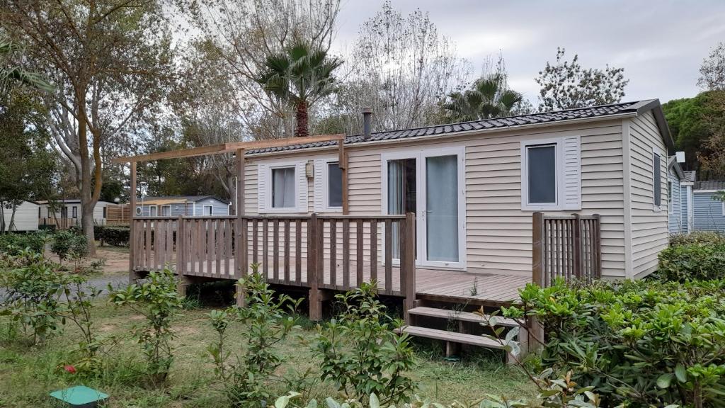 a tiny house with a porch and a deck at Mobil Home AGDE Hérault in Agde
