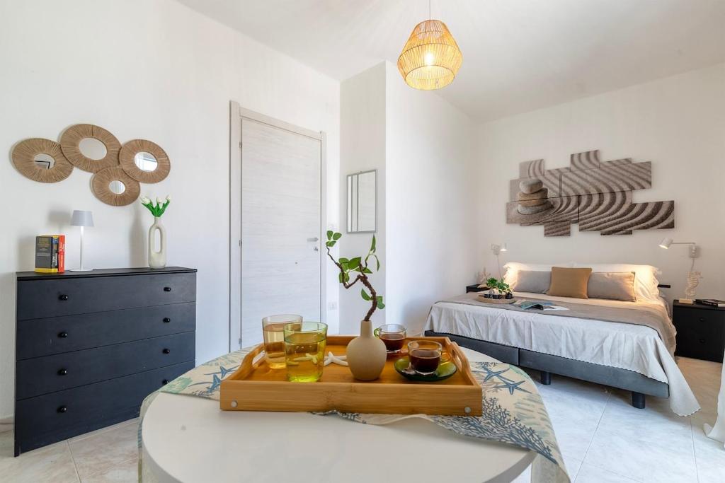 a room with a bed and a table with drinks on it at NURAS - Casa Aurelia square view old town in Alghero