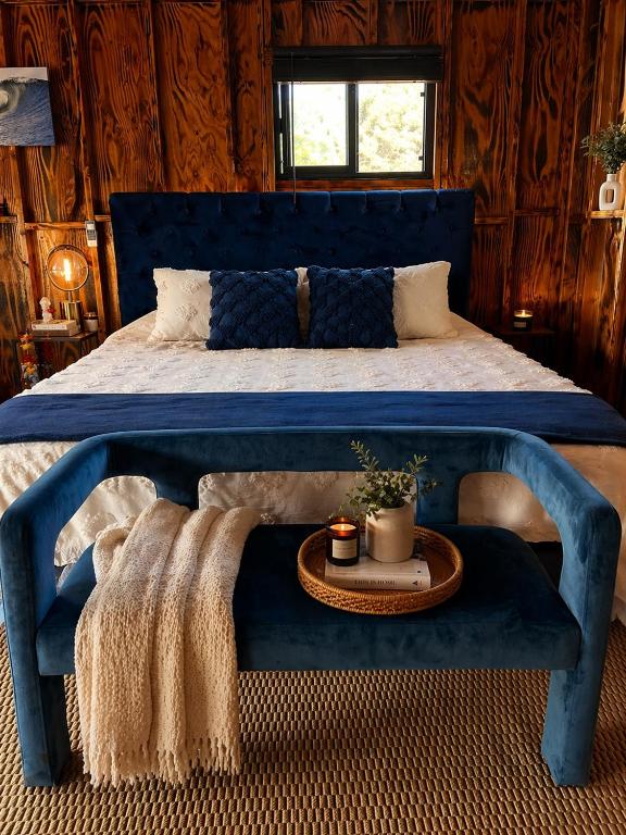 a bedroom with a blue bed with a table on it at Sunset Calm Retreat Bungalow in Haleiwa