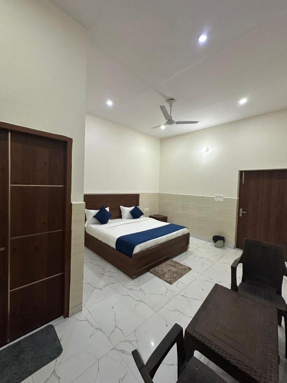 a bedroom with a bed and a chair at Hotel Gold in Faridabad