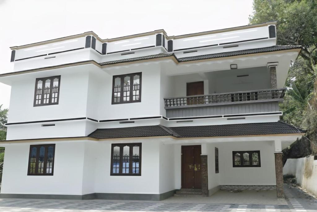 a white house with a balcony at Aditi Residency in Cochin