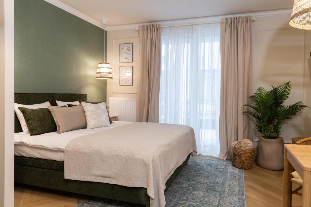 a bedroom with a bed and a large window at Milla Apartamenty 102 in Zamość
