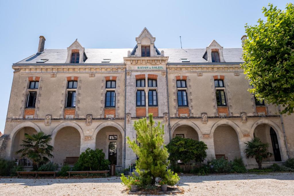 an old building with a tree in front of it at Le Rayon de Soleil in Châtelaillon-Plage