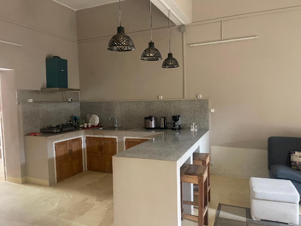 a kitchen with a counter and some pendant lights at Takasira Appartment Downtown 2 in Fort Dauphin