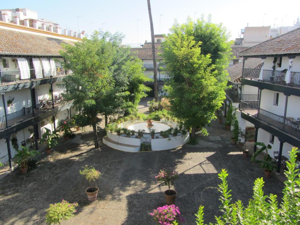 een luchtzicht op een binnenplaats met bomen en een fontein bij Monumento S.XVI Corralas in Sevilla